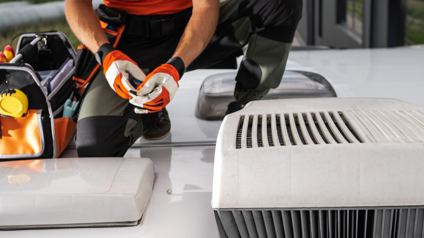 Technician working on RV electrical system wiring with tools
